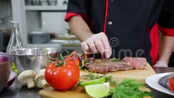 在厨房工作的厨师提供牛排视频的预览图