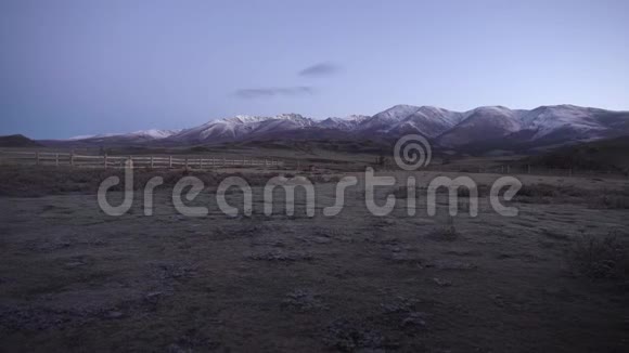 美丽的风景清晨在山上霜在草地上的前景背景雪峰视频的预览图