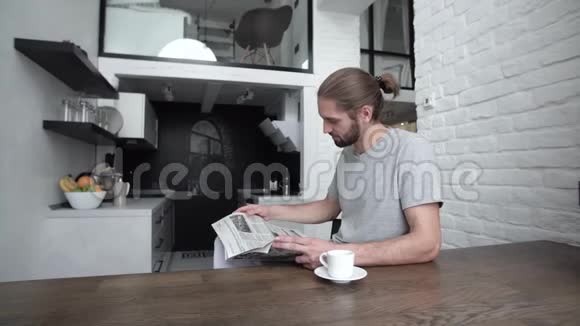 带报纸的男人在现代厨房喝早咖啡视频的预览图