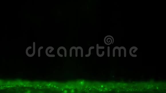 水滴落在绿色的五颜六色的水上视频的预览图