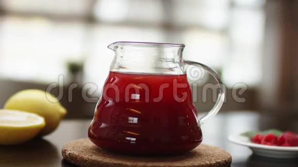 特写一个有热水和花红茶的茶壶动作慢一只手正在木器上用茶壶装饰茶视频的预览图