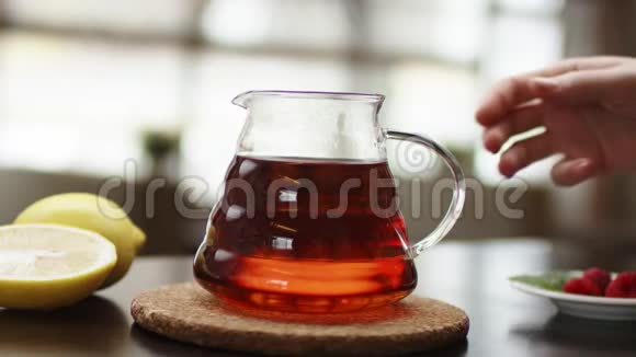 茶被倒入玻璃透明茶杯中一杯茶糖果热茶和茶壶陶瓷茶壶和玻璃茶杯视频的预览图