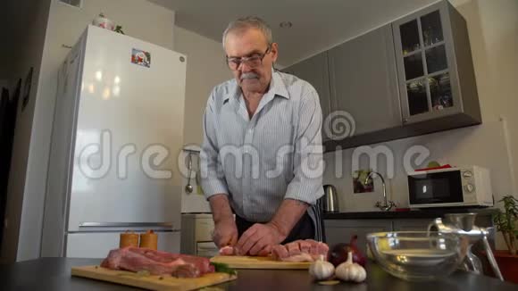 在厨房切猪肉的老人视频的预览图