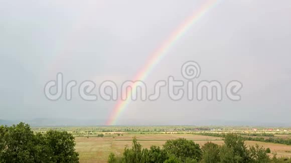 彩虹在山景和多云多雨的天空中的时间流逝视频的预览图