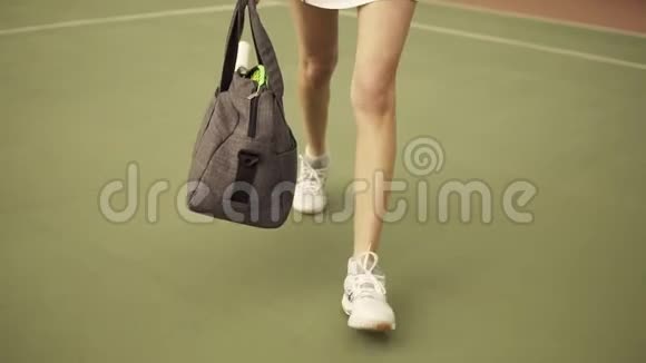为年轻健康女性提供一个包和网球拍的腿部特写镜头并为球场上的训练做准备视频的预览图