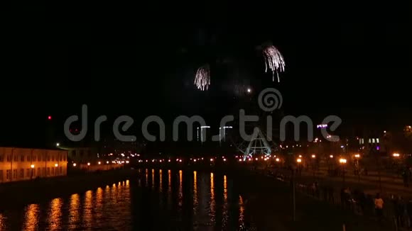 光明的烟花在城市的堤岸上在夜空中映在河中视频的预览图