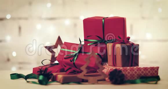 在闪烁的圣诞灯光背景上包装的礼物和装饰品视频的预览图
