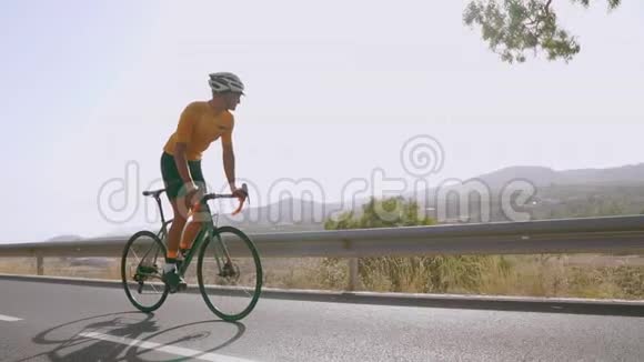一个人骑着一辆运动道路自行车在位于高山上的道路上慢动作视频的预览图