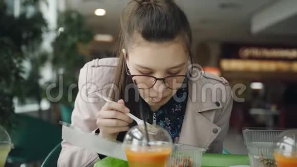 带眼镜的女孩在咖啡馆里吃面条视频的预览图