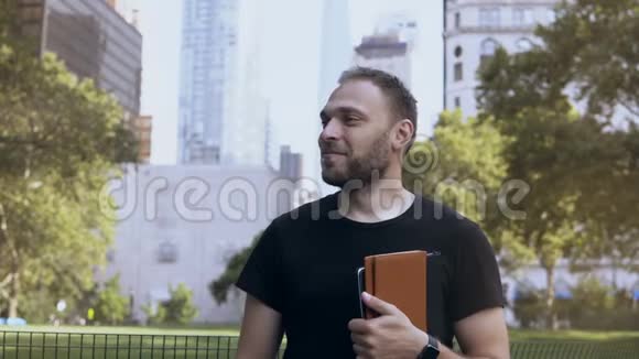 年轻英俊的男性工人肖像持有美国纽约金融区附近的文件视频的预览图