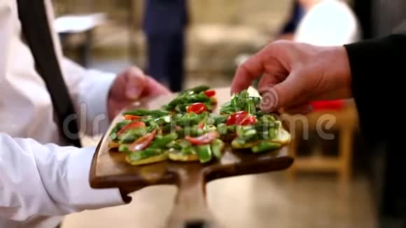 人们在婚礼上用餐盘吃服务员提供的主菜视频的预览图