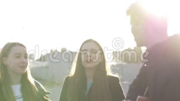 三个朋友用吉他唱歌在日落时玩得很开心视频的预览图