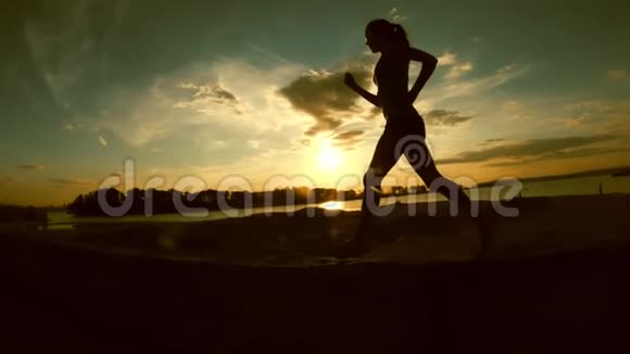 年轻迷人的女人在日落时分在公园里奔跑动作缓慢轮廓分明视频的预览图