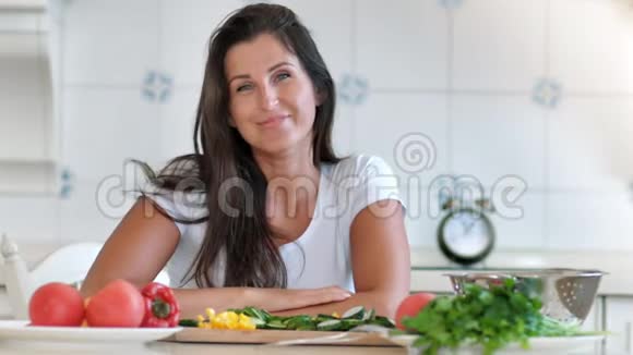 美丽的女人微笑在豪华住宅的白色厨房享受和放松的肖像视频的预览图