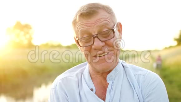 无忧无虑的退休男子微笑着看着相机一位戴眼镜的老人的肖像节日快乐父亲节视频的预览图