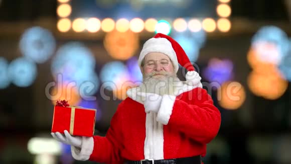 圣诞老人微笑着指着礼物盒视频的预览图