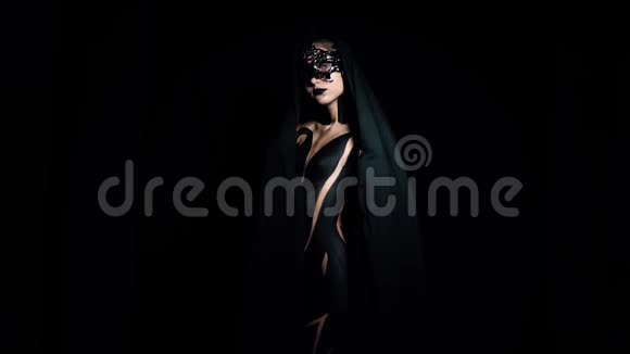 一个身材苗条的黑人女孩站在黑暗中用一块布遮住自己动作缓慢视频的预览图
