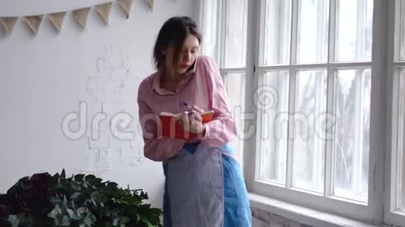 专业的花艺师在电话上讲话在笔记本上写笔记视频的预览图