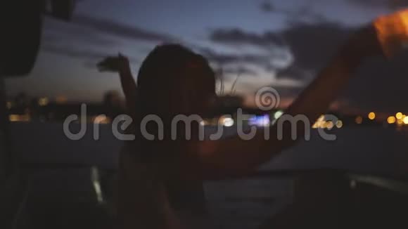 美丽的年轻女子在船甲板上跳舞晚上有孟加拉灯女人很开心视频的预览图