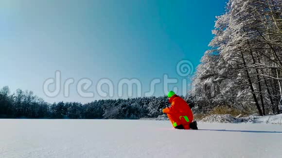 躺在冰冻湖表面的摄影师视频的预览图