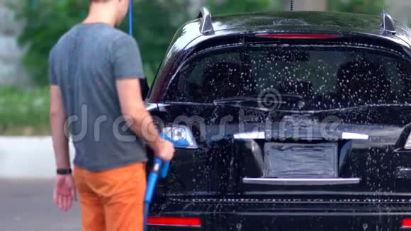 年轻人在洗车场的车上喷泡沫视频的预览图