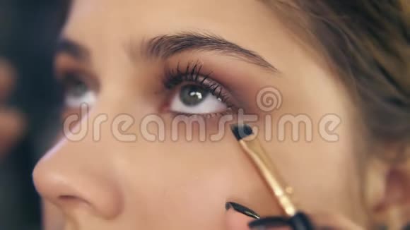 专业化妆师的近景用化妆刷涂抹眼影慢镜头视频的预览图