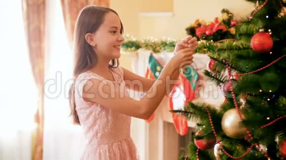 4k视频美丽的微笑女孩装饰圣诞树客厅与鲍布视频的预览图