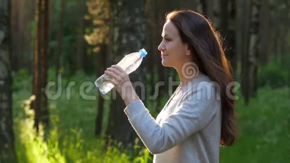 口渴的女人从瓶子里喝水视频的预览图