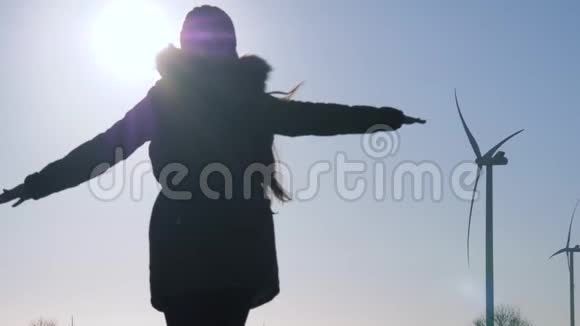 在风站上旋转到阳光下的女人剪影视频的预览图