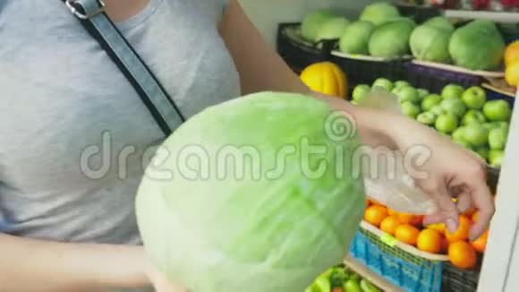 一个女人正在市场上选择蔬菜4k慢镜头女人买白菜视频的预览图