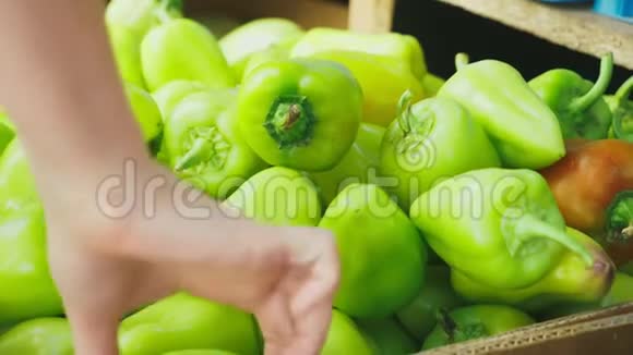 一个女人正在市场上选择蔬菜4k慢镜头女人买保加利亚胡椒视频的预览图