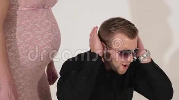 戴墨镜的金发帅哥在孕妇旁边唱歌跳舞视频的预览图