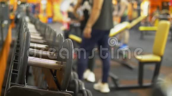 模糊的背景健身房里的哑铃人们在健身房用哑铃做运动视频的预览图