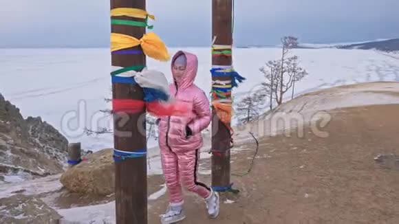 在冬天的山顶上享受户外散步的女人在冬天用彩带做的佛教仪式柱视频的预览图