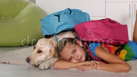 女孩带着她的狗准备上学躺在地毯上视频的预览图