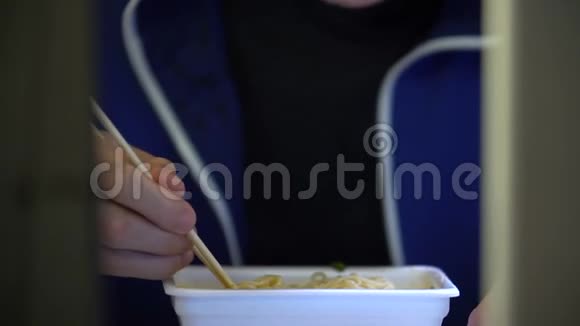 年轻人在电脑显示器前用筷子吃面条视频的预览图