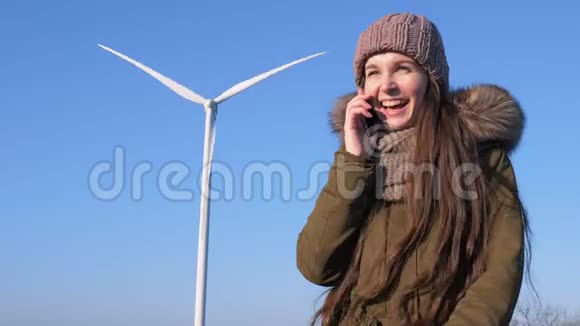 移动通信幸福的女孩在风电机组旁用手机聊天视频的预览图