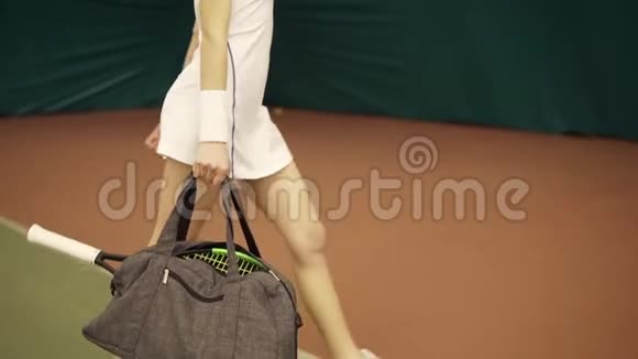 为年轻健康女性提供一个包和网球拍的腿部特写镜头并为球场上的训练做准备视频的预览图