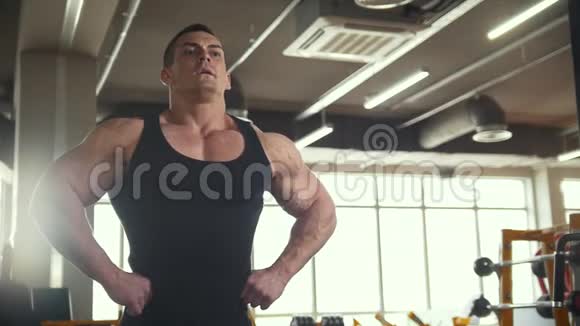 强壮的男人在健身房的镜子前热身视频的预览图