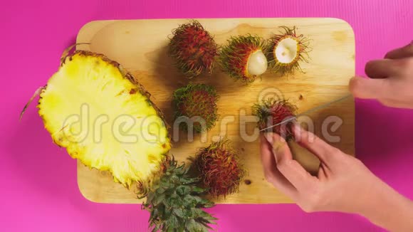 俯视图中女性手拿刀在木板上切水果菠萝和拉布坦自然健康的概念视频的预览图