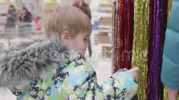 商店里的孩子看着货物出售玩具和圣诞树直到圣诞节为亲人送圣诞礼物视频的预览图