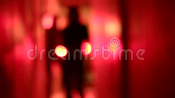 两个穿高跟鞋的女人在一条模糊的红色走廊里跳舞的剪影视频的预览图