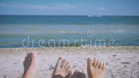 男人和女人脚在沙滩上靠在大海上嬉戏有趣地扭动手指恋爱中的情侣浪漫视频的预览图