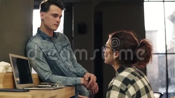 两个随便的人年轻人和一个女孩互相交谈在室内视频的预览图