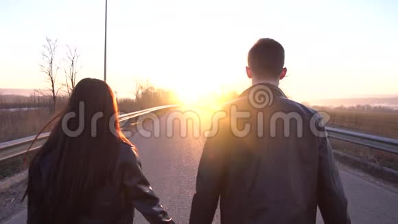 一对相爱的夫妇正在夕阳下沿着这条路走慢悠悠着视频的预览图