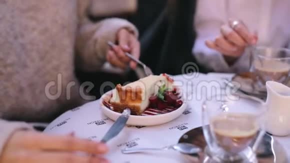 两个漂亮的年轻女人坐在咖啡馆或餐馆的桌子前吃早餐视频的预览图