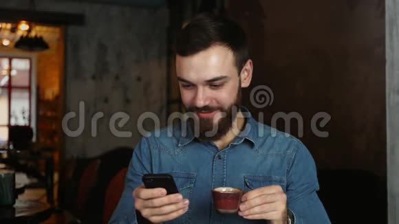 咖啡馆里留着胡子的年轻人的肖像蓝色衬衫男士写留言视频的预览图