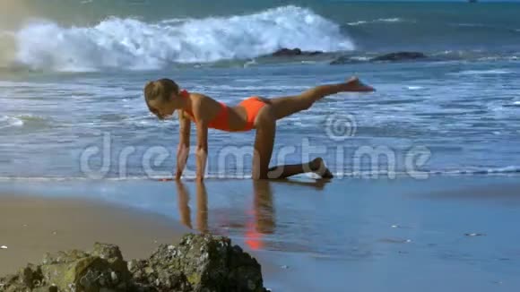 瘦女孩站在沙滩浅水的膝盖上锻炼视频的预览图