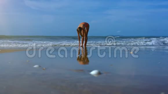 苗条女孩在沙滩上用泡沫支撑瑜伽姿势视频的预览图