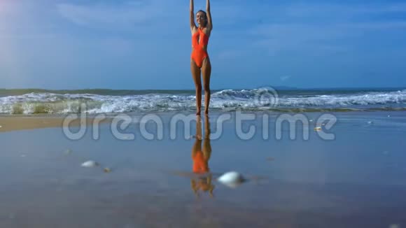 女孩站在瑜伽位置海滩美丽海景视频的预览图